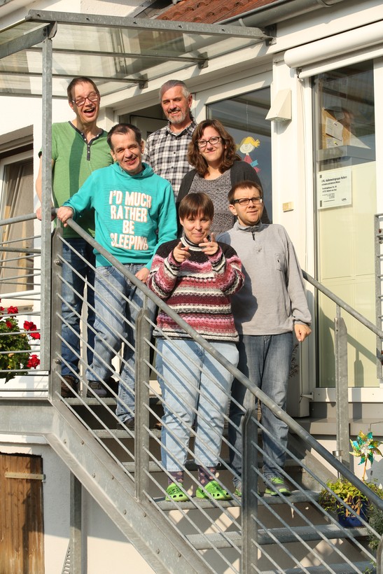 Gruppenfoto von vier Männern und zwei Frauen auf einer Metalltreppe Gruppenfoto von vier Männern und zwei Frauen auf einer Metalltreppe