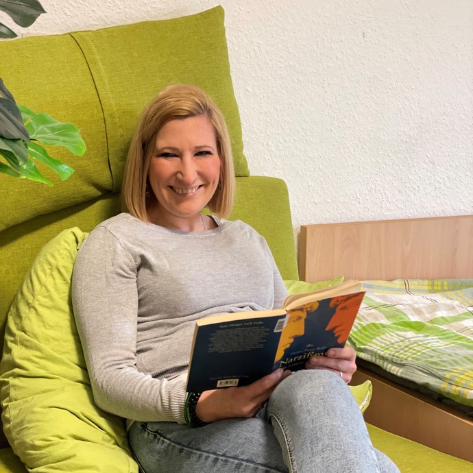 Eine Frau sitzt im Sitzsack und liest (vergrößerte Bildansicht wird geöffnet)